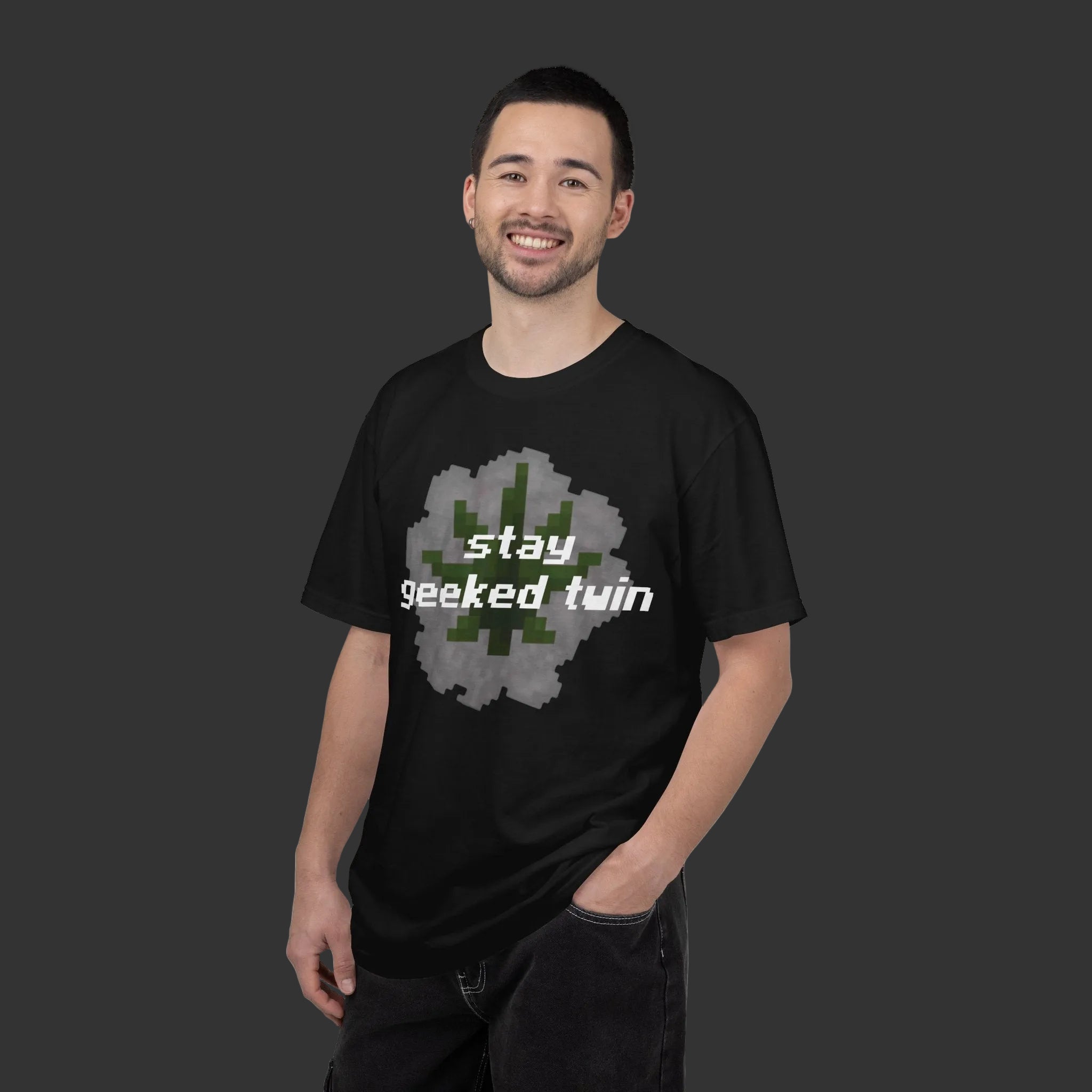 Man wearing a black t-shirt with 'stay geeked twin' text and pixelated design on a white background